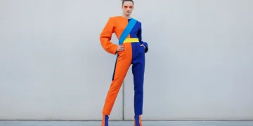 Model wearing color blocking trends outfit with orange and blue panels